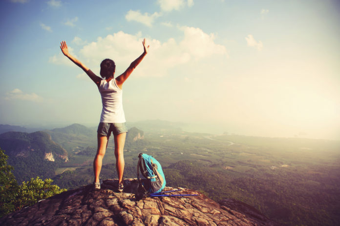 woman hiker enjoy the view on mountain peak cliff reasons to start living healthy today