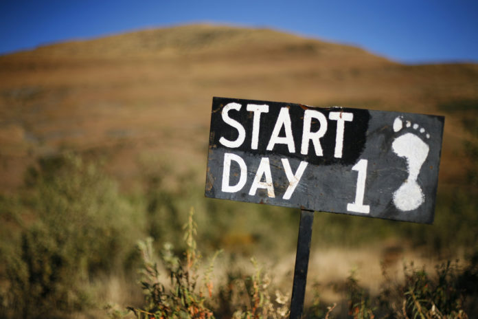 Monochrome sign showing start of hiking trail plus scenery