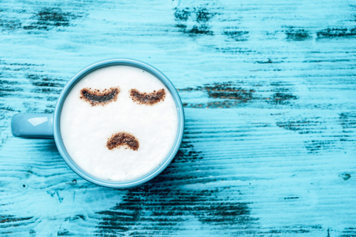 cup of cappuccino with a sad face